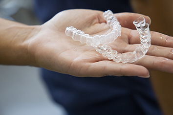 Zwei Invisalign Schienen liegen auf Handfläche